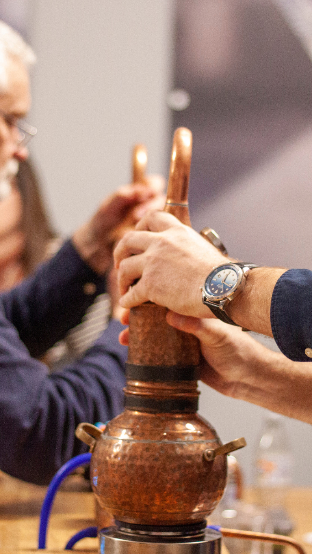 Hands securing copper still at corporate event at Nelson's Gin, Vodka & Rum School portrait.