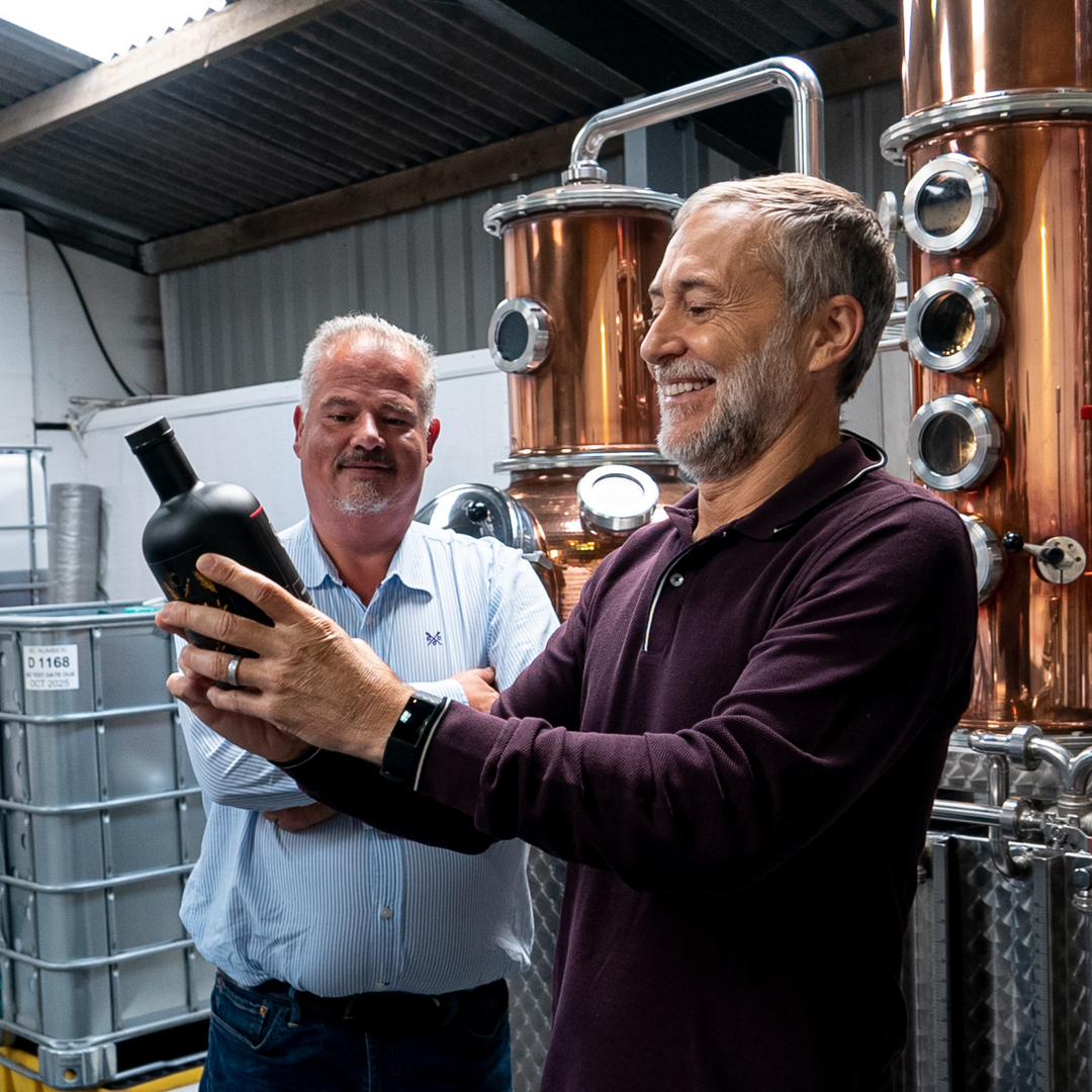 Michel Roux Jr holding Le Gavroche Gin at Nelson's Distillery & School