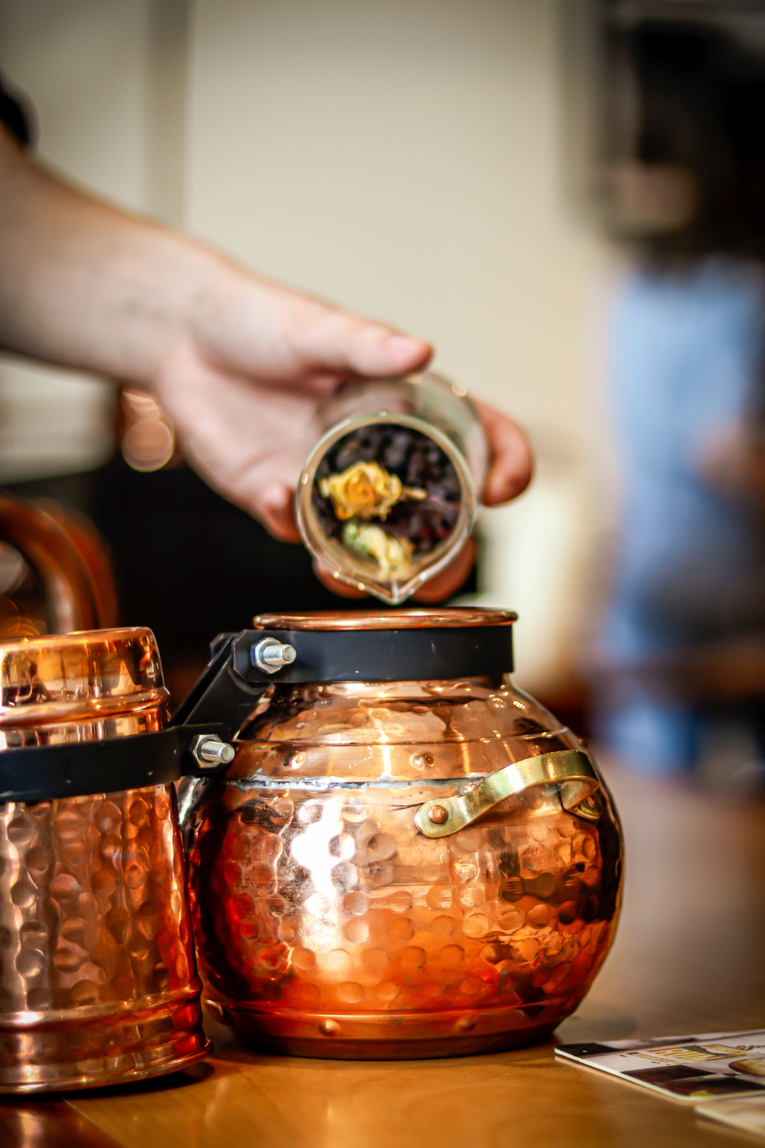 Nelson's Gin, Vodka & Rum School student poring botanicals into open micro still.