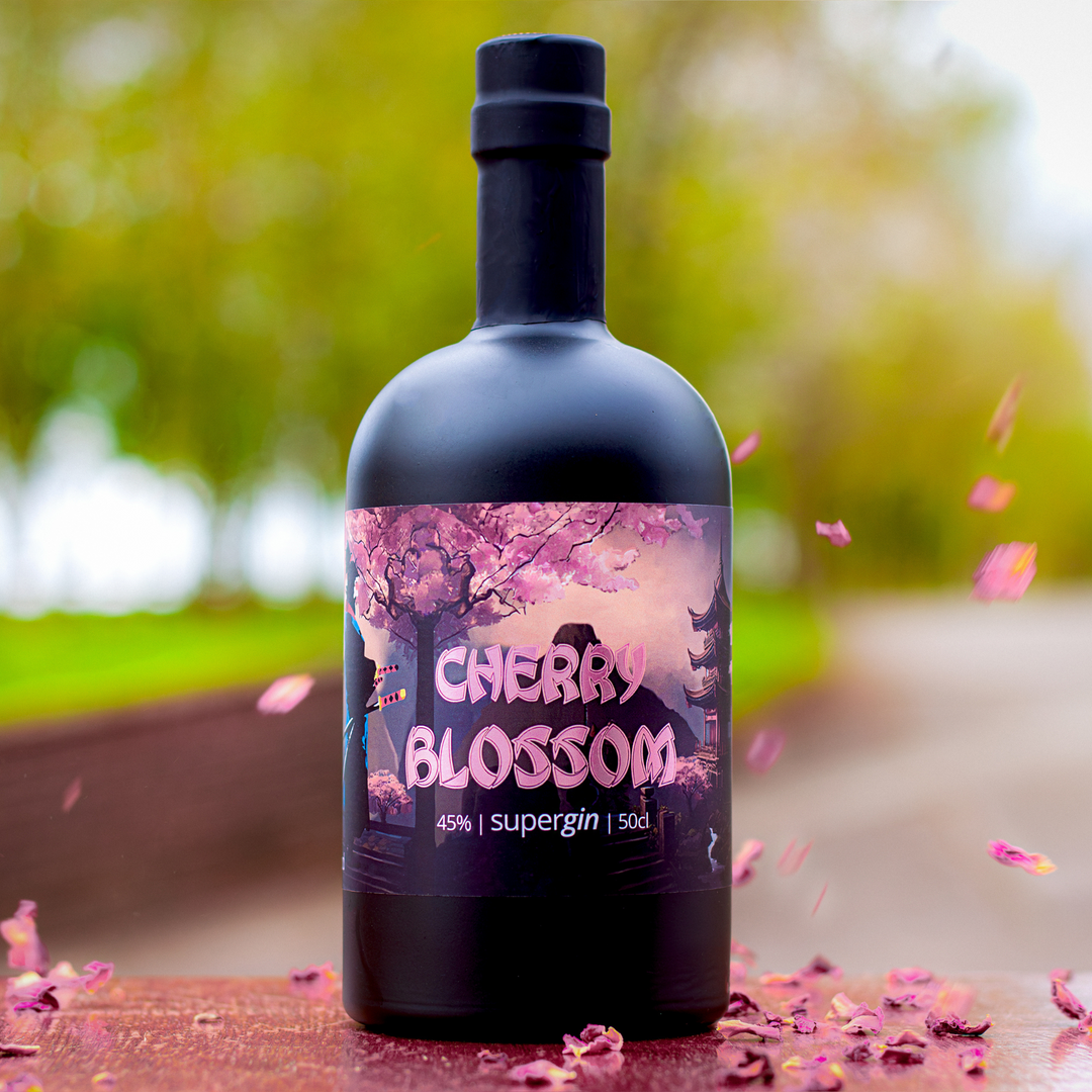 Roy Wood's Cherry Blossom Gin with petals blowing in wind set outside with blurred landscape background.